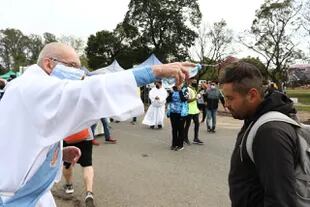 Un sacerdote bendice a uno de los participantes de la peregrinación a pie a Luján 