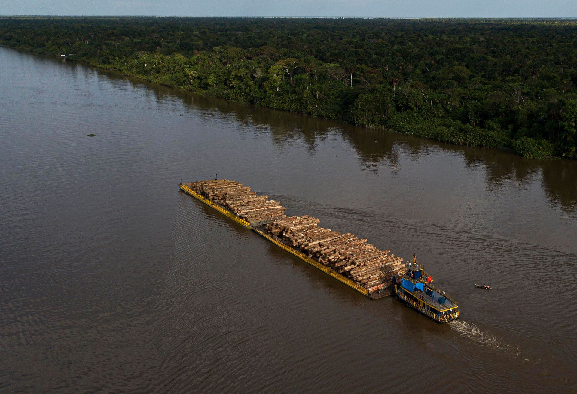Vista aérea que muestra una embarcación que transporta troncos de madera en una barcaza a lo largo del río Buissu en el municipio de Melgaco, estado de Pará