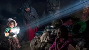 Una niña sostiene un plato de comida caliente mientras la familia Avila almuerza en su casa en Coata, un pequeño pueblo en la orilla del lago Titicaca, en la región de Puno, Perú.
