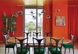 Mesa de nogal (Kerylos Intérieurs), sillas de Guglielmo Ulrich tapizadas con terciopelo y lámpara de la gran Lindsey Adelman. Las cortinas se hicieron con género de Hermès en su naranja característico.