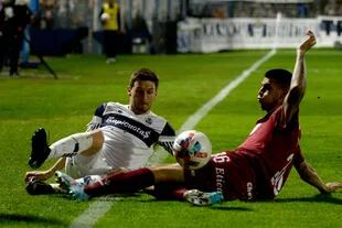 Soldano y Ortellado disputan la pelota en el piso, sobre la línea lateral