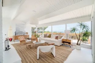 The living room has a large window overlooking the Pacific Ocean
