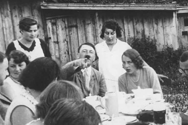 Adolf Hitler durante una comida. Su sobrina Geli Raubal está sentada a la derecha del líder nazi
