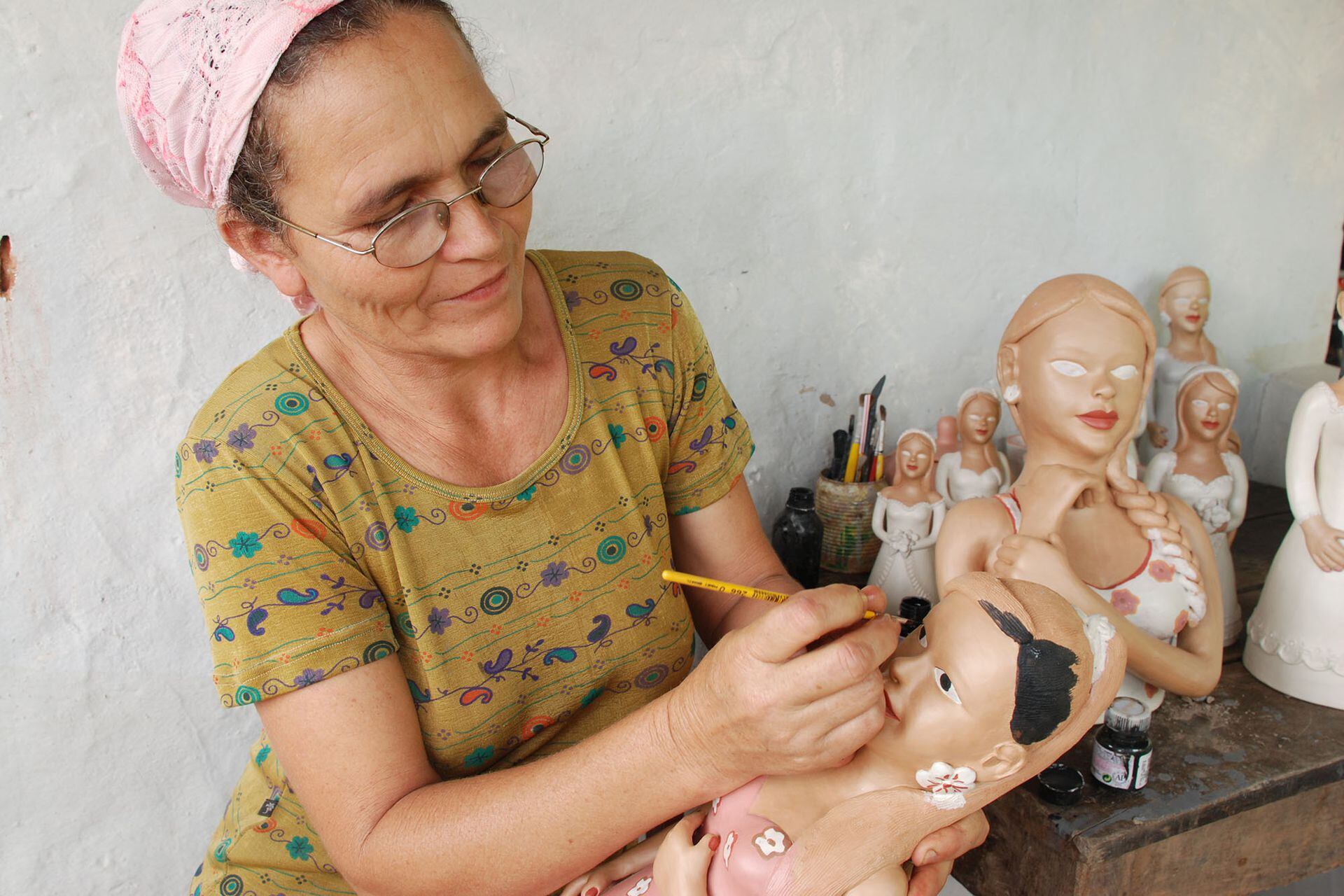Maria Salvina Silva pinta los ojos de su muñeca en Cachoeira do Fanado