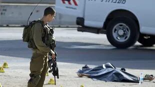 Un soldado israelí junto al cuerpo de un palestino abatido ayer tras un atque con cuchillo