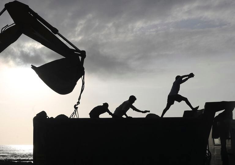 Trabajadores operan maquinaria en un proyecto de construcción en una vialidad costera en Mumbai, India, el jueves 26 de agosto de 2021. (AP Foto/Rafiq Maqbool)