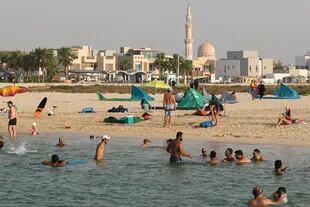La gente se reúne en una playa en el emirato del Golfo de Dubai el 26 de junio de 2020