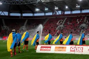 Los jugadores de Shakhtar Donetsk salen a la cancha con la bandera de su país, Ucrania; de los 14 extranjeros que había en el plantel apenas quedó uno desde que estalló el conflicto con Rusia