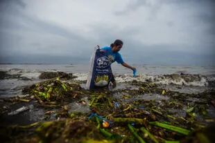 Un joven junta basura del mar en Manila, Filipinas
