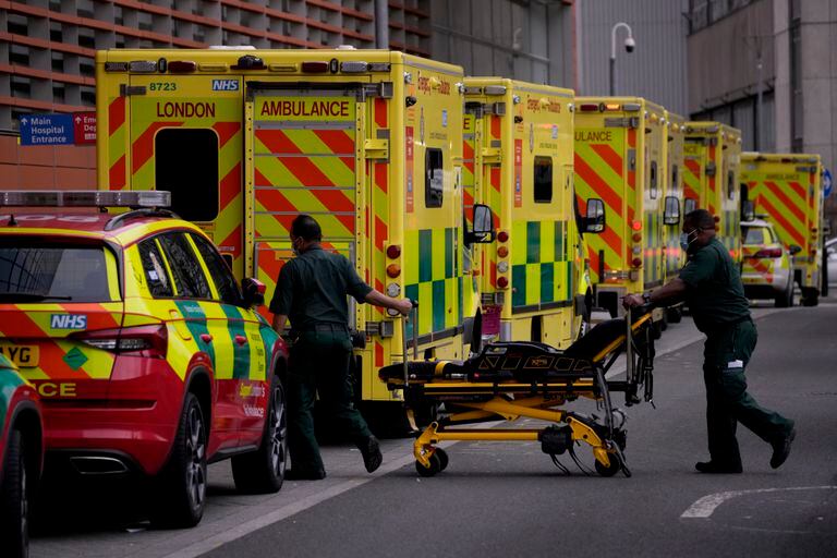 Paramédicos empujan una camilla hacia una fila de ambulancias en el exterior del Royal London Hospital en la zona de Whitechapel, al este de Londres, el 6 de enero de 2022. (AP Foto/Matt Dunham)