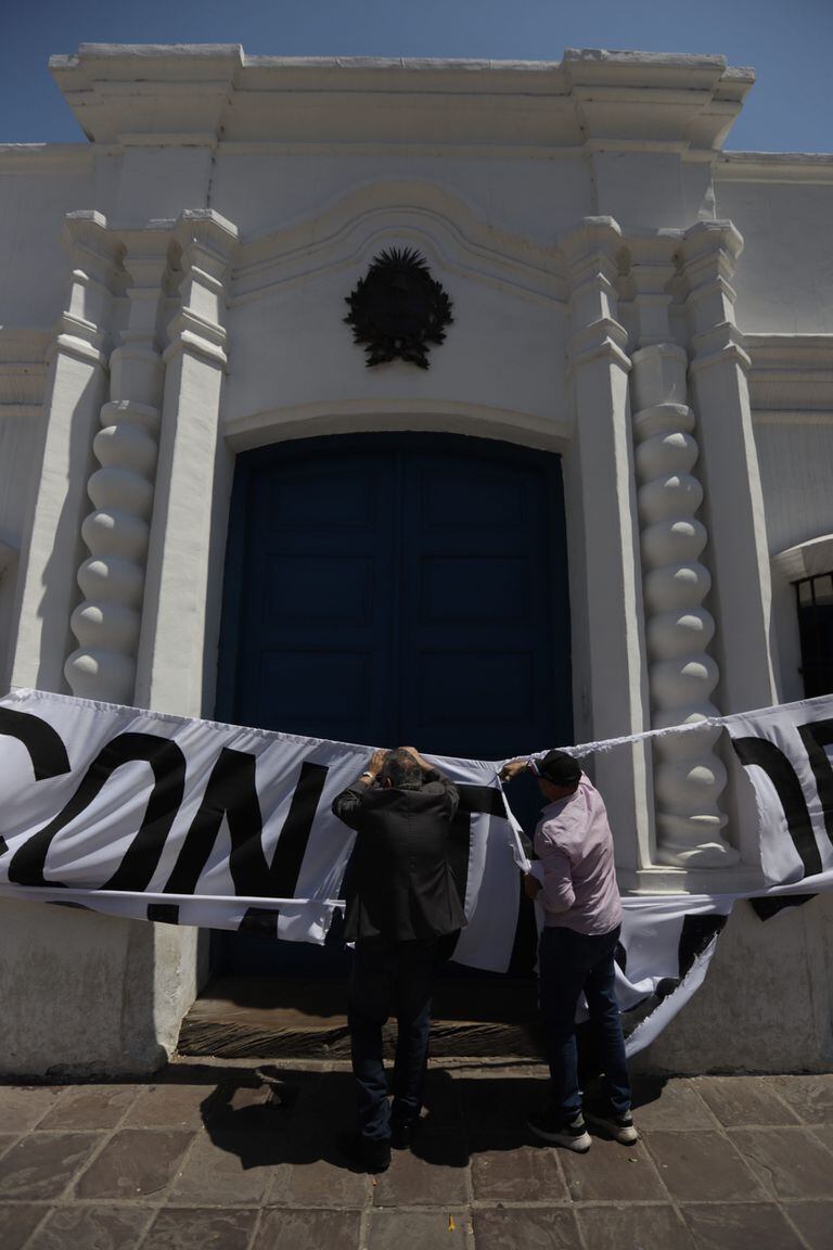 Manifestantes rompen la obra instalada en la fachada de la casa de Tucumán. Foto: Gianni Bulacio