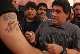 Maradona firma autógrafos a la salida de un programa de TV, en 2009
