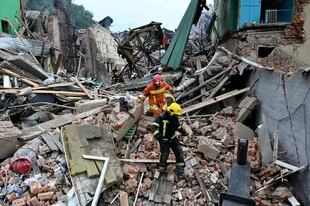 Equipos de rescate cavan entre los escombros de los edificios destruidos en los ataques nocturnos en una búsqueda de supervivientes, en la ciudad de Chuhuiv, región de Kharkiv, el 25 de julio de 2022, en medio de la invasión rusa de Ucrania.