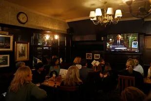 El discurso del rey, en un pub en Londres. (Photo by CARLOS JASSO / AFP)
