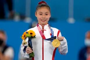 La gimnasia es una las disciplinas en las que China es muy exitosa; Guan Chenchen celebra su primer puesto en la barra de equilibrio.