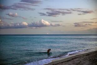 Un nadador en la playa cerca del Deauville Beach Resort en Miami Beach, el jueves 13 de enero de 2022