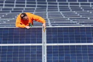 Un técnico revisa la instalación de un panel solar en España