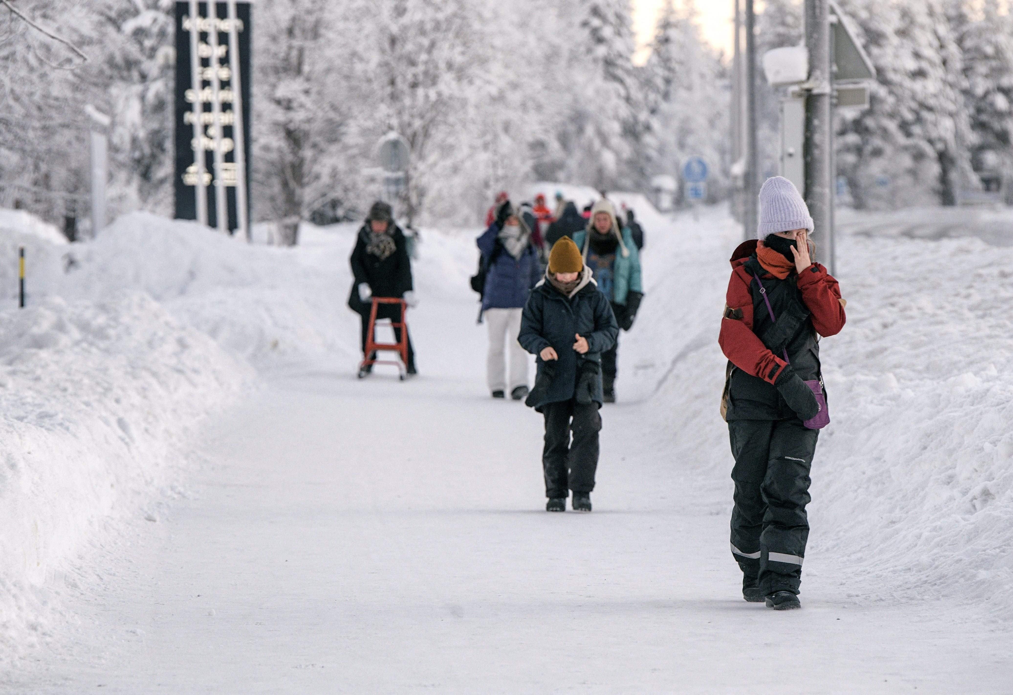 La gente camina en un paisaje nevado en la ciudad de Äkäslompolo, en el municipio de Kolari en la Laponia finlandesa el 4 de enero de 2024, durante condiciones de congelación extrema que persistirán durante toda la semana no solo en Laponia sino en toda Finlandia.