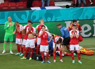 Los jugadores de Dinamarca reaccionan cuando su compañero de equipo Christian Eriksen yace en el suelo durante el partido del grupo B del campeonato de fútbol de la Eurocopa 2020 entre Dinamarca y Finlandia en el estadio Parken en Copenhague