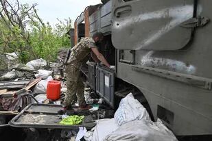 Un militar ucraniano inspecciona un vehículo militar ruso destruido cerca de la aldea de Mala Rogan al este de Kharkiv, el 13 de mayo de 2022