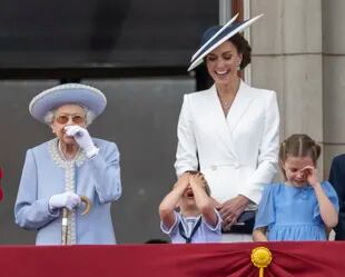 La reina Isabel II; el príncipe Louis; Kate, la duquesa de Cambridge; la princesa Charlotte, y el príncipe George se reúnen en el balcón del Palacio de Buckingham, Londres, mientras ven pasar un avión de la Royal Air Force. (Paul Grover, Pool Photo via AP)
