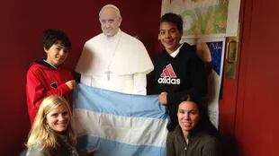 Una familia de argentinos posa junto a una imagen del Papa, en Filadelfia