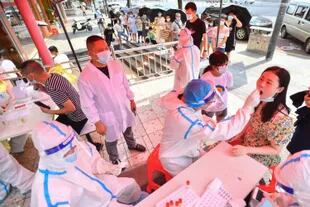 Trabajadores de la salud operan en un sitio de pruebas nucleicas de la COVID-19 en China