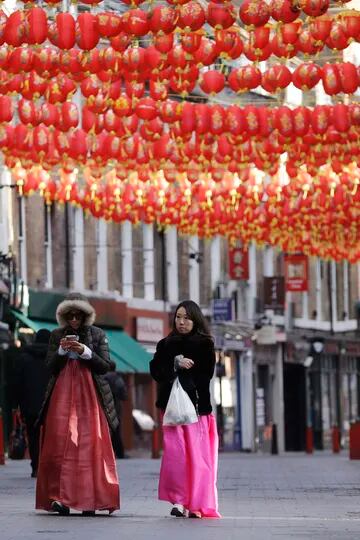 Mujeres caminan bajo linternas colgadas para celebrar el Año Nuevo Lunar chino, en el distrito de Chinatown del centro de Londres. Las celebraciones del Año Nuevo Chino se silenciaron en Londres mientras Inglaterra permanece en su tercer bloqueo nacional desde que comenzó el brote de coronavirus