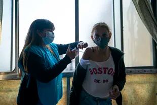 Una enfermera vacuna a María Rosa con una dosis de la vacuna Sinopharm para el COVID-19 en el barrio Fuerte Apache en la provincia de Buenos Aires, Argentina, el miércoles 18 de agosto de 2021. (AP Foto/Víctor R. Caivano)