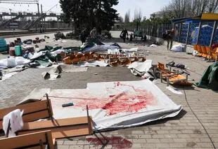 Las pertenencias personales de las víctimas y las lonas manchadas de sangre se ven en la plataforma después de un ataque con cohetes en la estación de tren en la ciudad oriental de Kramatorsk, en la región de Donbass el 8 de abril de 2022 (Photo by Anatolii STEPANOV / AFP)