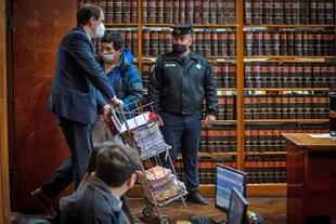 El secretario del tribunal, Rodrigo Burgos, lleva una pila de expedientes en el inicio de un nuevo juicio contra Milagro Sala