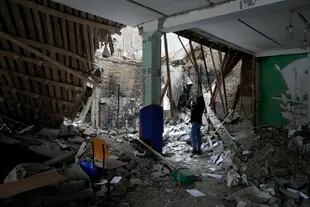 Una mujer toma fotos de un edificio de alojamiento destruido cerca de un puesto de control en Brovary, en las afueras de Kyiv, Ucrania, el martes 1 de marzo de 2022.