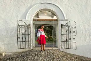 Una mujer ecuatoriana vestida con traje típico da la bienvenida a los huéspedes