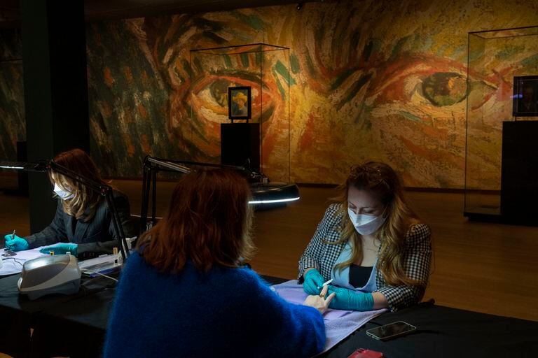 With the eyes of Van Gogh looking at the scene, a woman gets a manicure at the Amsterdam museum in protest of the cultural halls against the continuous closures due to the coronavirus