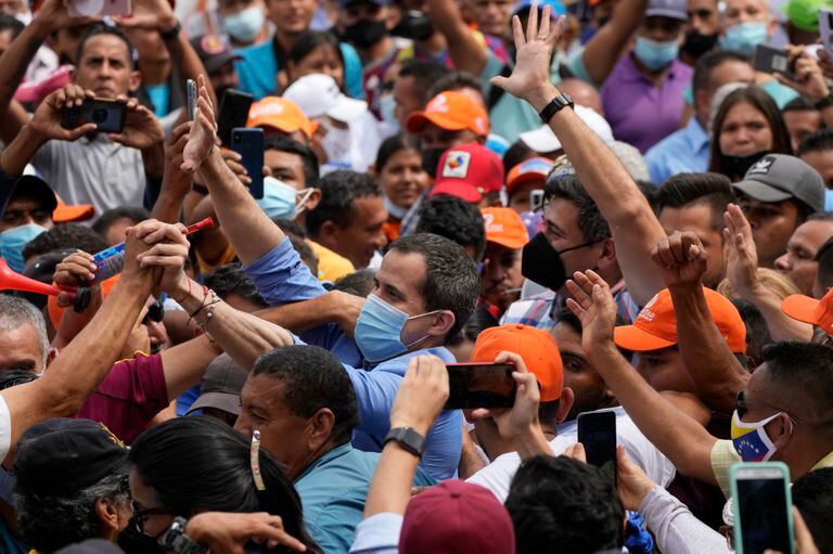 Los líderes opositores venezolanos Juan Guaidó, en el centro a la izquierda, y Freddy Superlano saludan a sus partidarios durante un mitin en apoyo a Superlano, en Barinas, Venezuela, el sábado 4 de diciembre de 2021. (AP Foto/Ariana Cubillos)