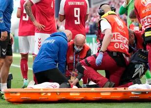 Christian Eriksen, de Dinamarca, es trasladado en camilla después de colapsarse en el campo durante el partido del grupo B por el campeonato de fútbol de la Eurocopa 2020