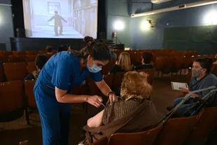 En el reformado cine Lumiere de la ciudad de Rosario, las personas adultas mayores miran películas de Chaplin antes y mientras son vacunadas.
Rosario, marzo 2021