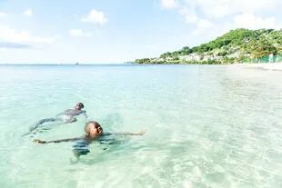 Dos personas disfrutan del agua cristalina de las costas de Grenada