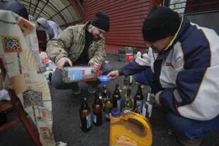 En las calles de Ucrania, un grupo de civiles cargan botellas con petróleo