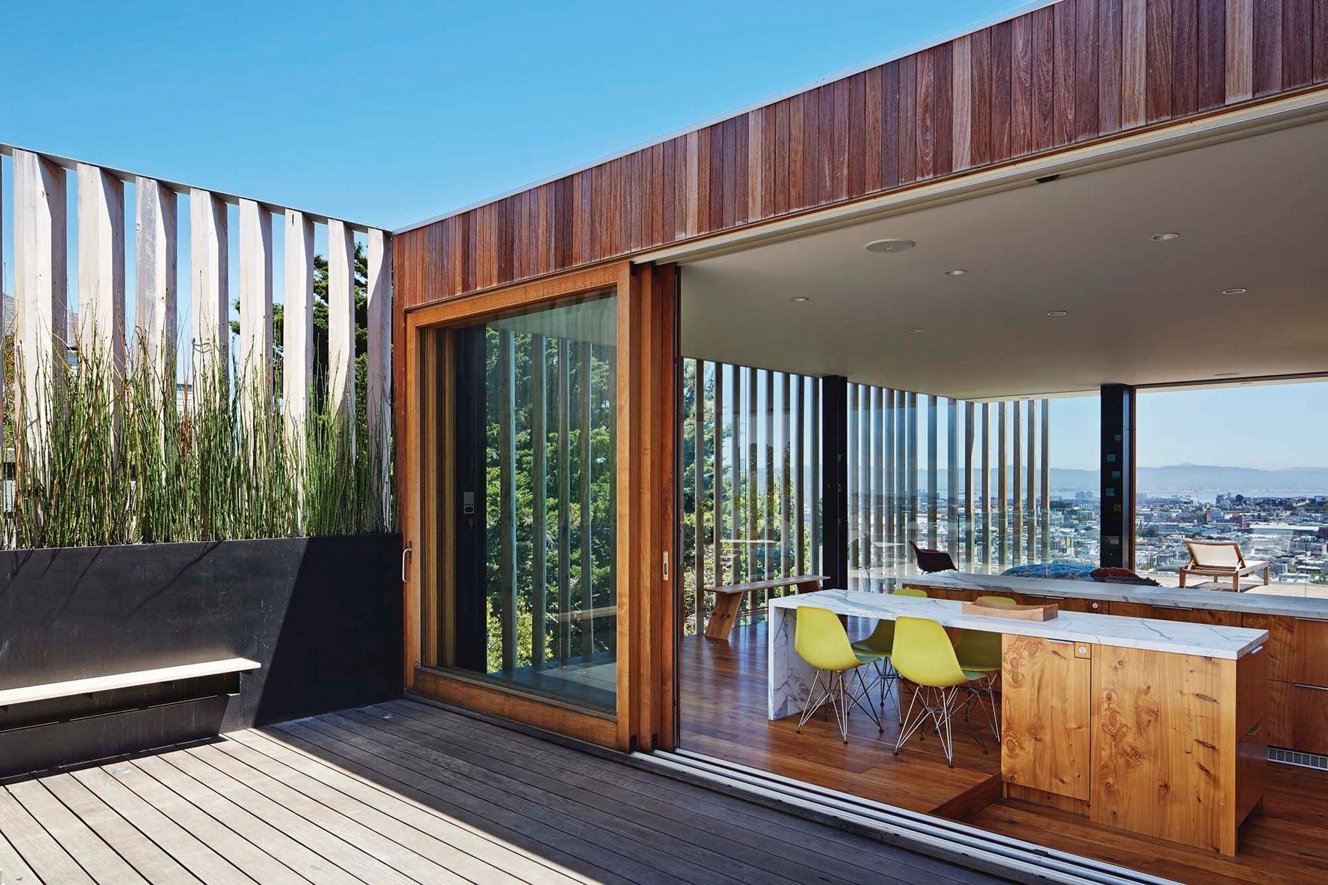 El living con comedor y cocina integrada tiene 150 m2, pero está diseñado de un modo tal que el deck se siente como una parte estructuralmente natural de él.