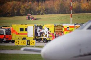 Personal médico traslada a pacientes desde un avión de la fuerza aérea rumana en el aeropuerto de Hamburgo, en Alemania (Gregor Fischer/dpa via AP)