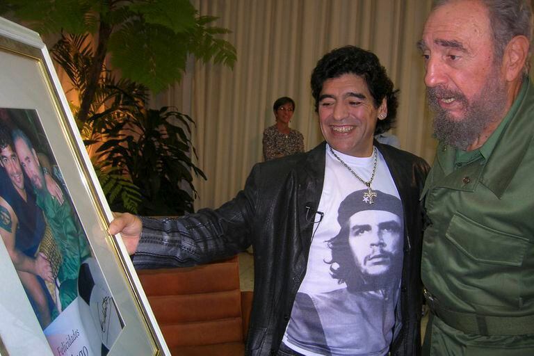 Diego Maradona y Fidel Castro miran una foto de ambos