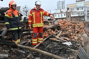 Rescatistas ucranianos acceden a los escombros para despejar en un edificio residencial, parcialmente destruido tras un ataque con misiles en Kharkiv 