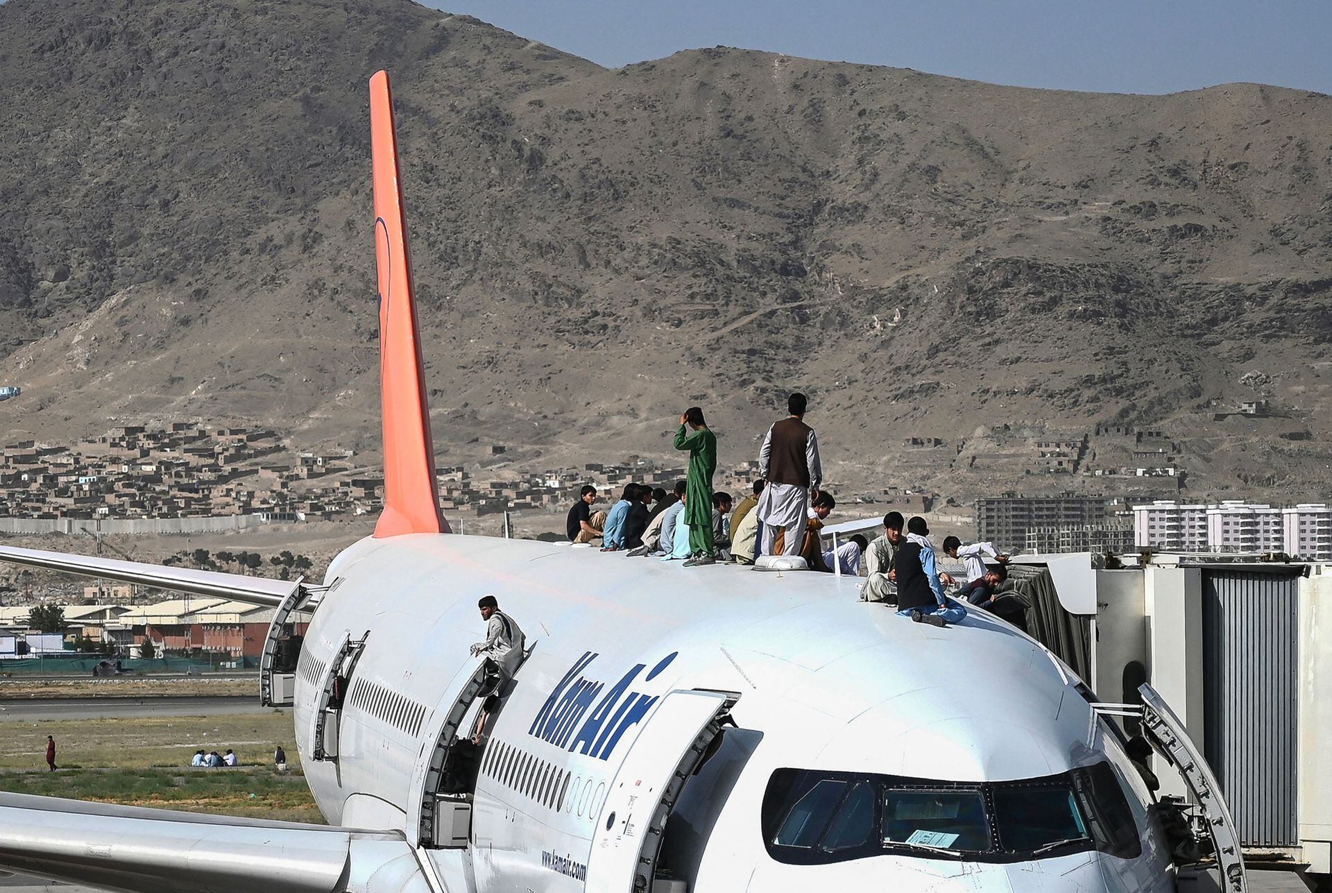 La imagen que recorrió el mundo: afganos subidos al techo y a las alas de un avión que estaba a punto de despegar del aeropuerto de Kabul, en un desesperado intento de huir de los talibanes