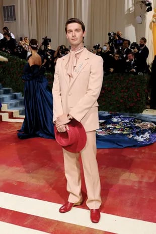 El hijo de Arnold Schwarzenegger, Patrick, desfiló la red carpet con un traje en tono salmón que completó con un sombrero rojo.