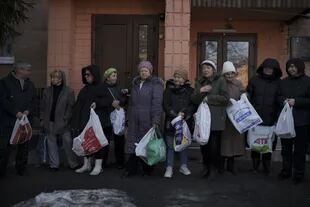 Residentes esperan en fila para recibir ayuda de Cruz Roja ucraniana, en Ucrania, el 24 de marzo de 2022. (AP Foto/Felipe Dan