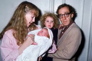 Mia Farrow y Woody Allen, quien sostiene en brazos a Dylan, en 1988