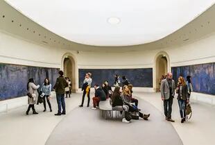Visitantes admiran la obra de Claude Monet en un espacio y con luces tal cual quería el autor. En el Museo De L'Orangerie, en París