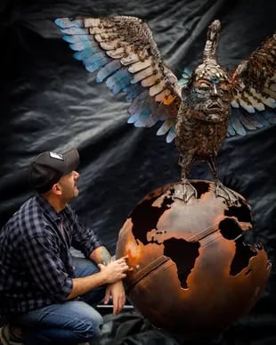 El escultor Julián Provenzano y una de sus obras de "scrap art"