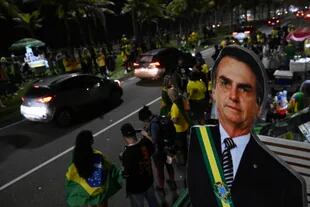 Los partidarios del presidente brasileño y candidato a la reelección, Jair Bolsonaro, reaccionan mientras observan el conteo de votos de las elecciones legislativas y presidenciales, en Río de Janeiro, Brasil, el 2 de octubre de 2022. 